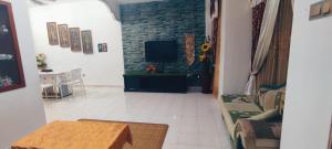 a living room with a couch and a tv at NazAnie Homestay in Kota Tinggi