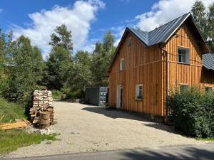 a barn with a pile of logs in front of it at Mlýnská 53 in Kraslice