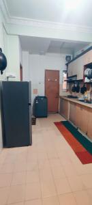 a room with a kitchen with a counter and a refrigerator at NazAnie Homestay in Kota Tinggi