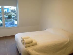 باتاغونيا أوسترال أبارتامينتوس في أوشوايا: سرير أبيض في غرفة بها نافذة