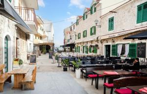 an empty street with tables and chairs and buildings at Centar Vodice Apartmani in Vodice