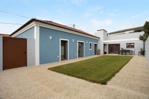 a white and blue house with a yard at Casa d'Avó em Santa Bárbara in Casa Nova