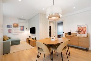 a dining room and living room with a table and chairs at Coastal Dreams - Casa Brisa in Nazaré