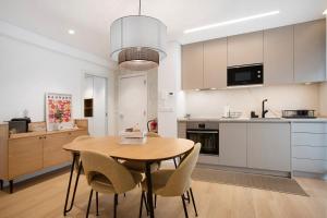 a kitchen and dining room with a wooden table and chairs at Coastal Dreams - Casa Brisa in Nazaré