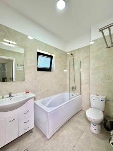 Un baño con bañera, inodoro y lavabo. en IN APART HOTEL, en Bucarest