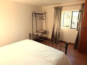 una camera da letto con un letto e una finestra di Adelaide's Cottage a Ponta do Pargo Altre 37 foto