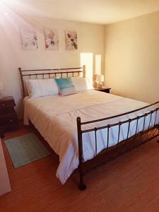 una camera da letto con un letto grande con lenzuola bianche di Adelaide's Cottage a Ponta do Pargo