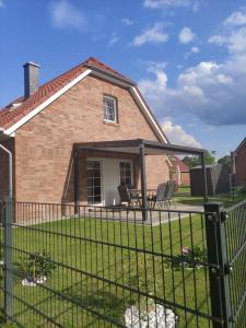 a yard with a fence in front of a house at Strandhaus Meeresluft in Hilgenriedersiel