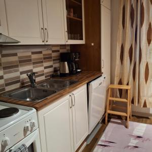 una cucina con mobili bianchi e un lavandino di Kontiopuisto a Pieksamaki