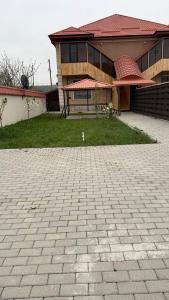 a house with a brick driveway in front of a building at Moy goust house in Qusar