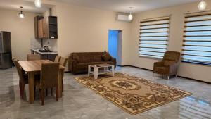 a living room with a table and chairs and a kitchen at Moy goust house in Qusar