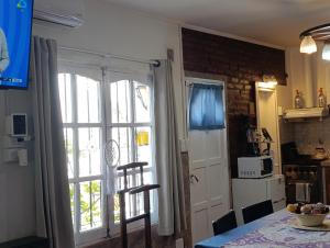 a kitchen with a table and a door with a window at Mi Loft in Tandil