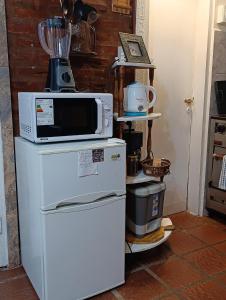 a kitchen with a microwave on top of a refrigerator at Mi Loft in Tandil +24 photos