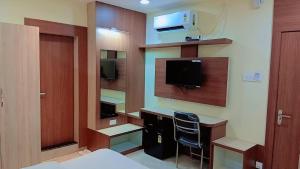 a room with a bedroom with a desk and a tv at Corporate Habitat in Bhubaneshwar