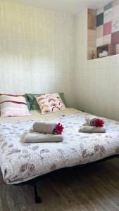 a bed with two pillows and red flowers on it at Casa a 4 zampe in Gorizia