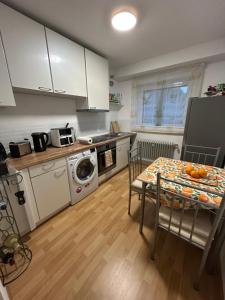 a kitchen with a table and a kitchen with a washing machine at Lunas FeWo in Römerberg