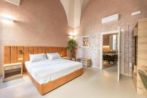 Dimora Suite Oro في غالّيبولي: غرفة نوم بسرير ومكتب وبيانو