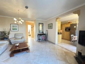 una sala de estar con un sofá y una mesa en Appartement avec piscine et loisirs, en Villeneuve-lès-Béziers 5 fotos más
