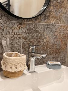 a bathroom sink with a faucet and a mirror at Mas de la Huppe - Franquevaux en Petite Camargue in Beauvoisin