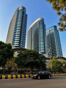 a car parked in front of three tall buildings at Luxurious 1BHK In Elysium Opposite Centaurus in Islamabad