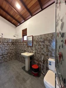 a bathroom with a sink and a toilet at Royal Resort in Weligama