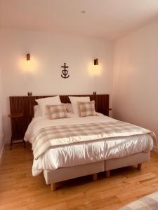 a bedroom with a large white bed with pillows at Mas de la Huppe - Franquevaux en Petite Camargue in Beauvoisin