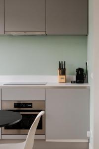 a white kitchen with a counter and a chair at Cosy City Apartment in Rotterdam West in Rotterdam