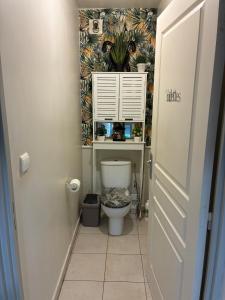 a bathroom with a toilet with a plant on the wall at Quiet, Zen garden 5 min to airport ocean view in Saint-Paul