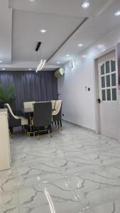 a room with a table and chairs and a door at Well Furnished 4 bedrooms duplex available! in Lekki +32 photos