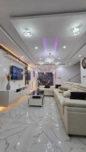 a large living room with couches and a tv at Well Furnished 4 bedrooms duplex available! in Lekki