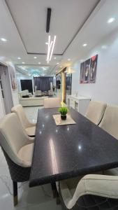 a dining room with a black table and chairs at Well Furnished 4 bedrooms duplex available! in Lekki
