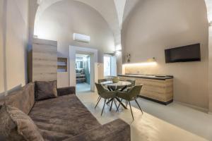 Dimora Suite Argento في غالّيبولي: غرفة معيشة بها أريكة وطاولة