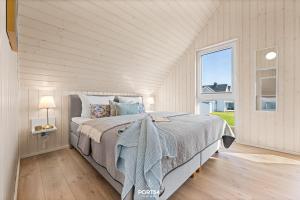 a bedroom with a bed and a large window at Ferienhaus Südheide Olpenitz in Olpenitz