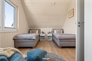 a attic room with two beds and a couch at Ferienhaus Südheide Olpenitz in Olpenitz
