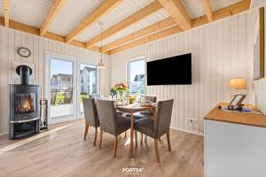 a dining room with a table and a wood stove at Ferienhaus Südheide Olpenitz in Olpenitz +23 photos