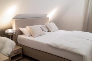 a bedroom with a bed with white sheets and pillows at Apartment Rosemary in Topolšica +40 photos