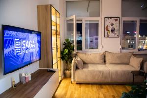 a living room with a couch and a flat screen tv at Central Saga Apartment in Skopje