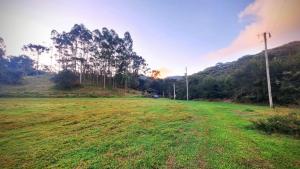 a field of grass with trees in the background at CABANA SERRA DA BALANÇA in Gonçalves