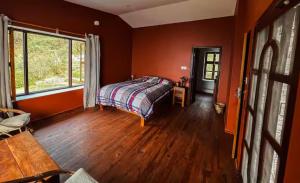 a bedroom with orange walls and a bed in a room at Mahakaruna mountain villa, peaceful family retreat with Himalayan views and Private Cook in Pokhara
