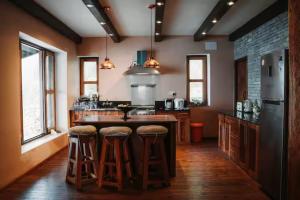 a kitchen with a island with bar stools at Mahakaruna mountain villa, peaceful family retreat with Himalayan views and Private Cook in Pokhara