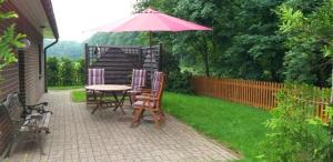a patio with a table and chairs and an umbrella at "Am Waldesrand" RE16 in Sögel