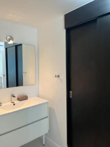 a bathroom with a black door and a sink at An oasis in the bay in Blue Bay