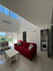 a living room with a red couch and a table at An oasis in the bay in Blue Bay