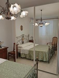 Un dormitorio con dos camas y un espejo. en B&B Nonna Rosa, en Castellaneta