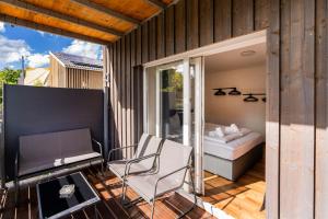 a room with a bed and a chair on a balcony at homy Central City Oasis in Dornbirn in Dornbirn