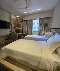 a hotel room with two beds and a desk at Aarambh By The Sky Imperial Indore in Indore