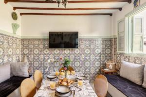 アル・ジャディーダにあるVue sur mer Riad Statia Votre refuge authentiqueのテーブルと壁にテレビが置かれたリビングルーム