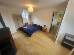 a bedroom with a blue bed and a wooden floor at Maison des Cimes, Garden, cozy for 8 people in Ayzac-Ost
