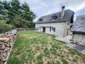 an external view of a stone house with a yard at Maison des Cimes, Garden, cozy for 8 people in Ayzac-Ost
