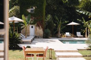 a patio with a table and chairs and a pool at Le Château Réal in Saint-Seurin-de-Cadourne